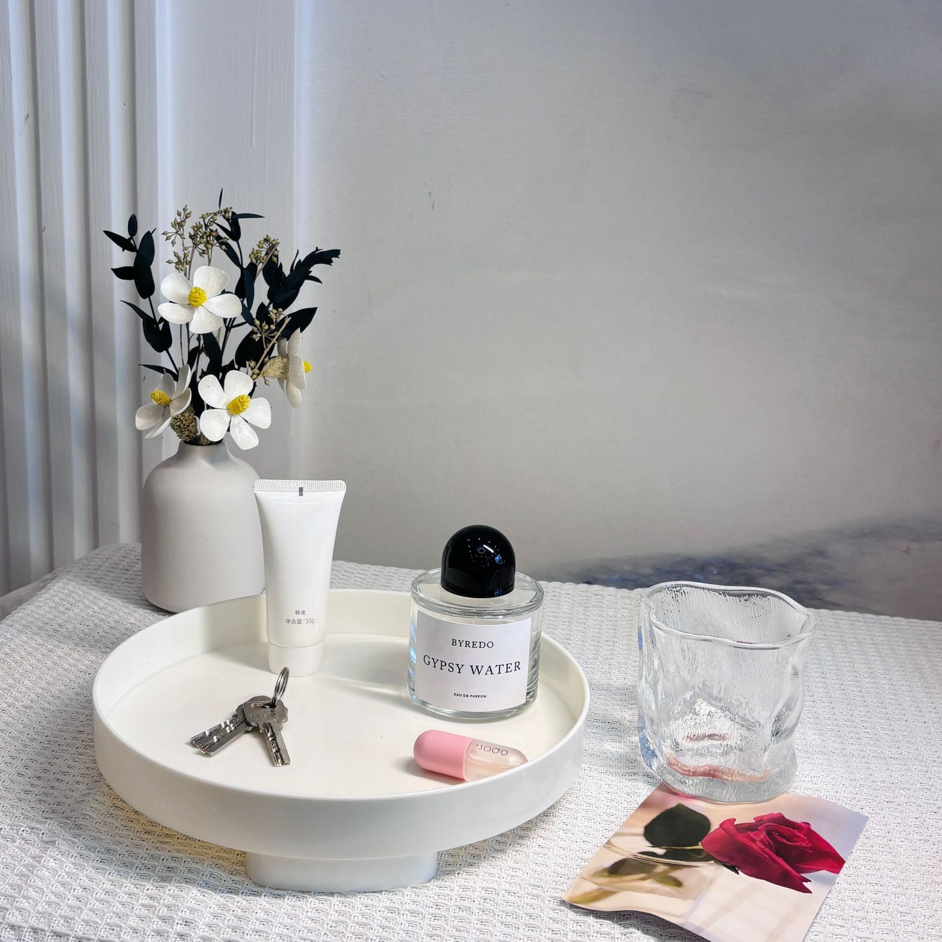 Bandeja branca ins desktop cosmetics storage box tray entrance ornaments storage tray com frases premium naturais para energia, vitalidade e saúde cognitiva, contendo chave, cremes, perfume e decoração floral minimalista sobre mesa clara.