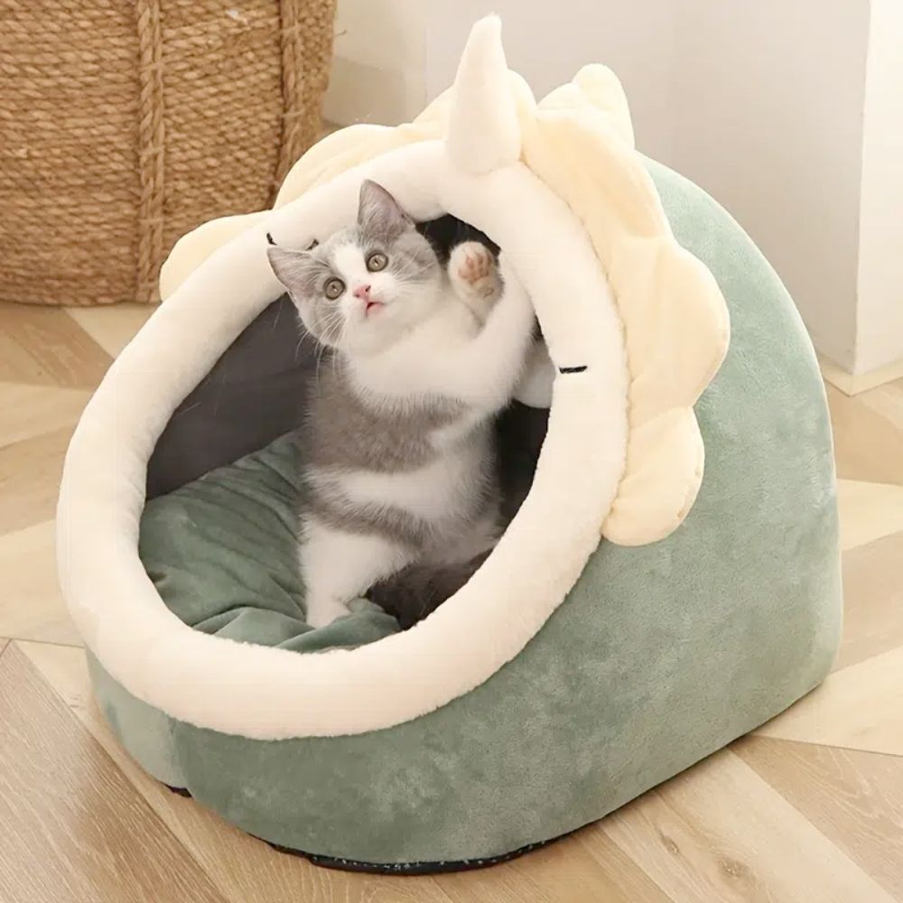 Gato brincando dentro da Adorable Dinosaur Pet House with Toy, cama acolchoada em tom verde suave, ideal para conforto e bem-estar natural dos pets em casa.