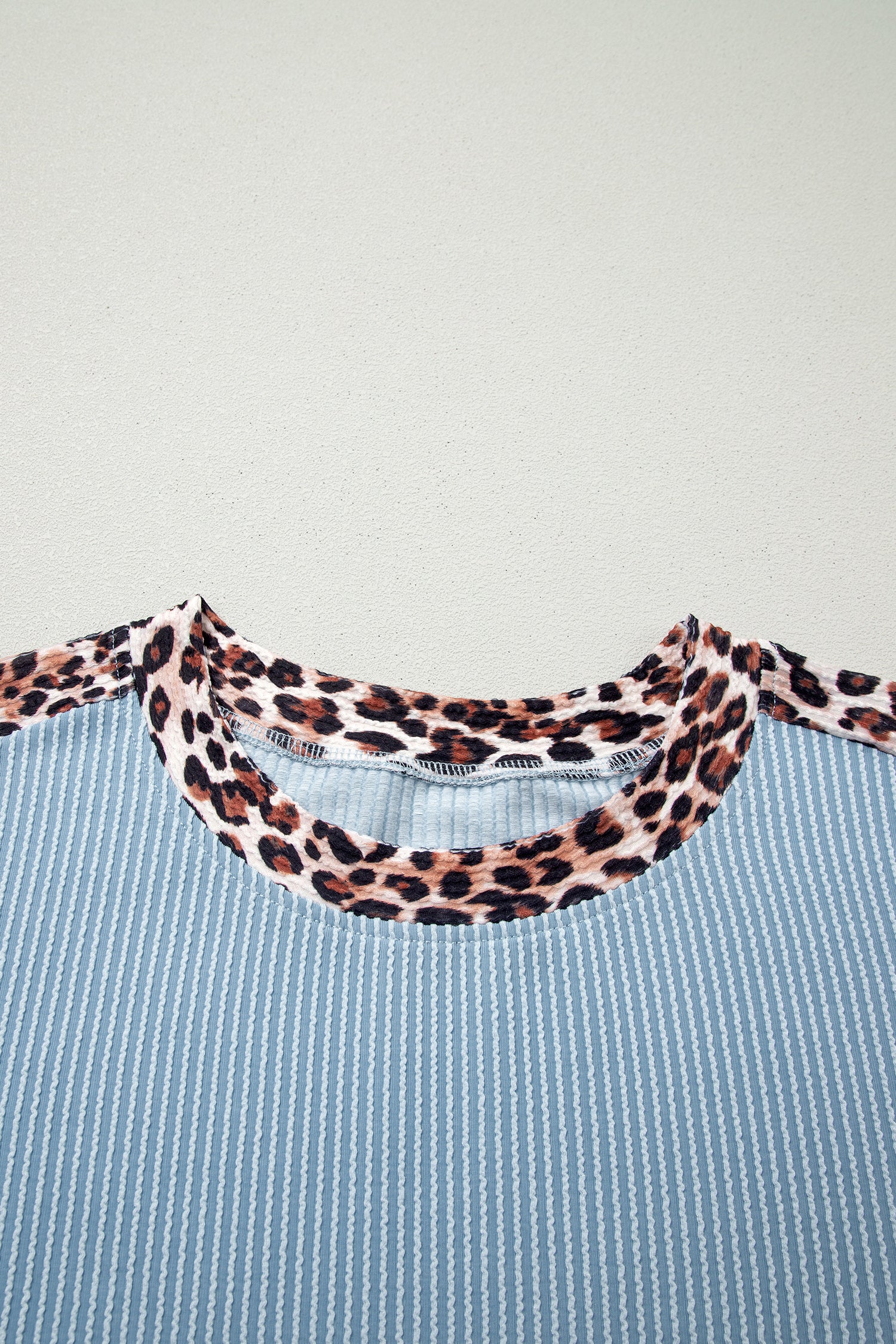 Detalhe da gola com estampa de oncinha em trim de tecido canelado cinza claro, parte do conjunto Light Grey Leopard Trim Twist Ribbed Short Set, ideal para quem busca conforto e estilo.