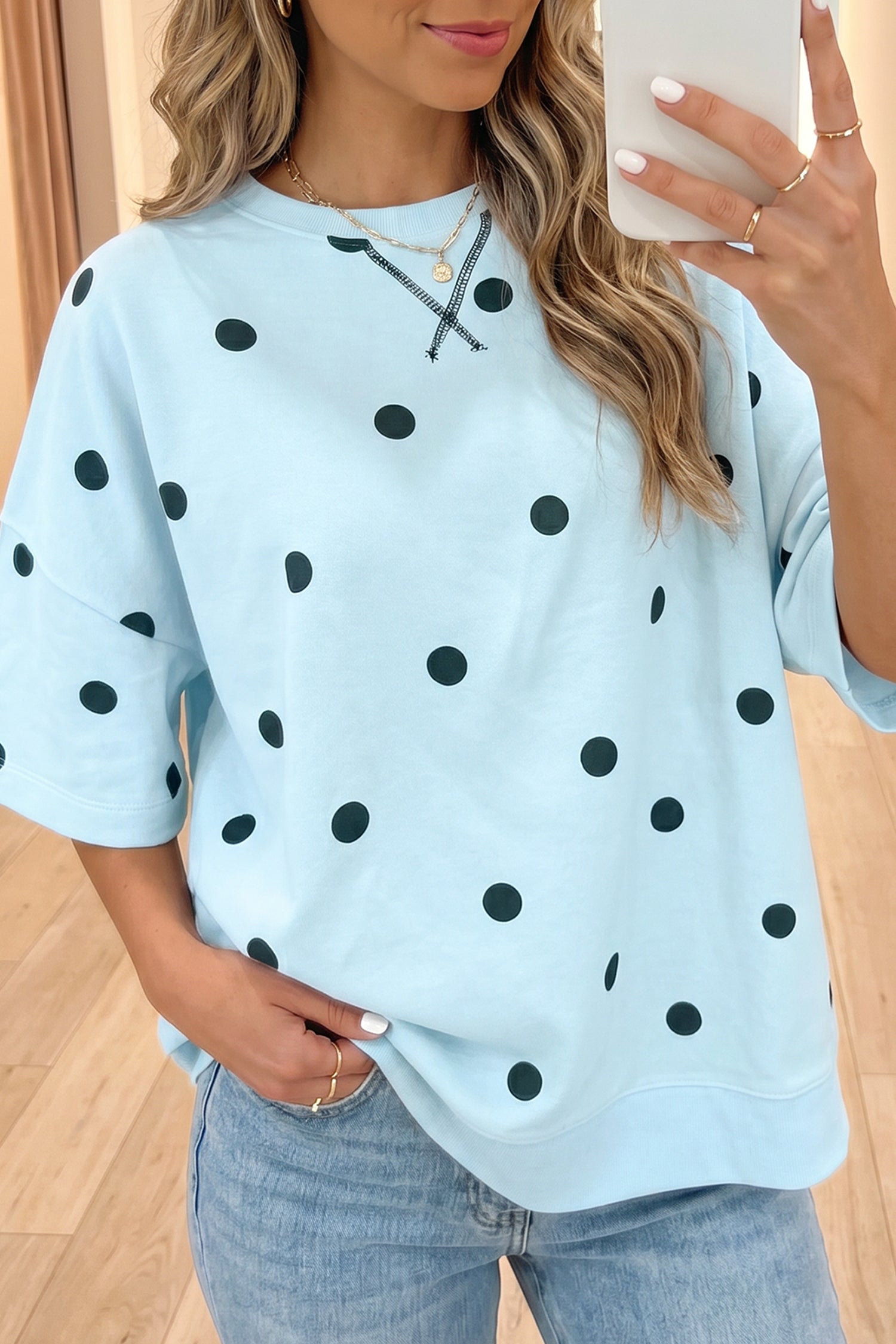 Mulher vestindo Yellow Polka Dot Print Crossed Seam Detail Oversize Tee azul claro com bolinhas pretas, combinando estilo casual com conforto para bem-estar natural.