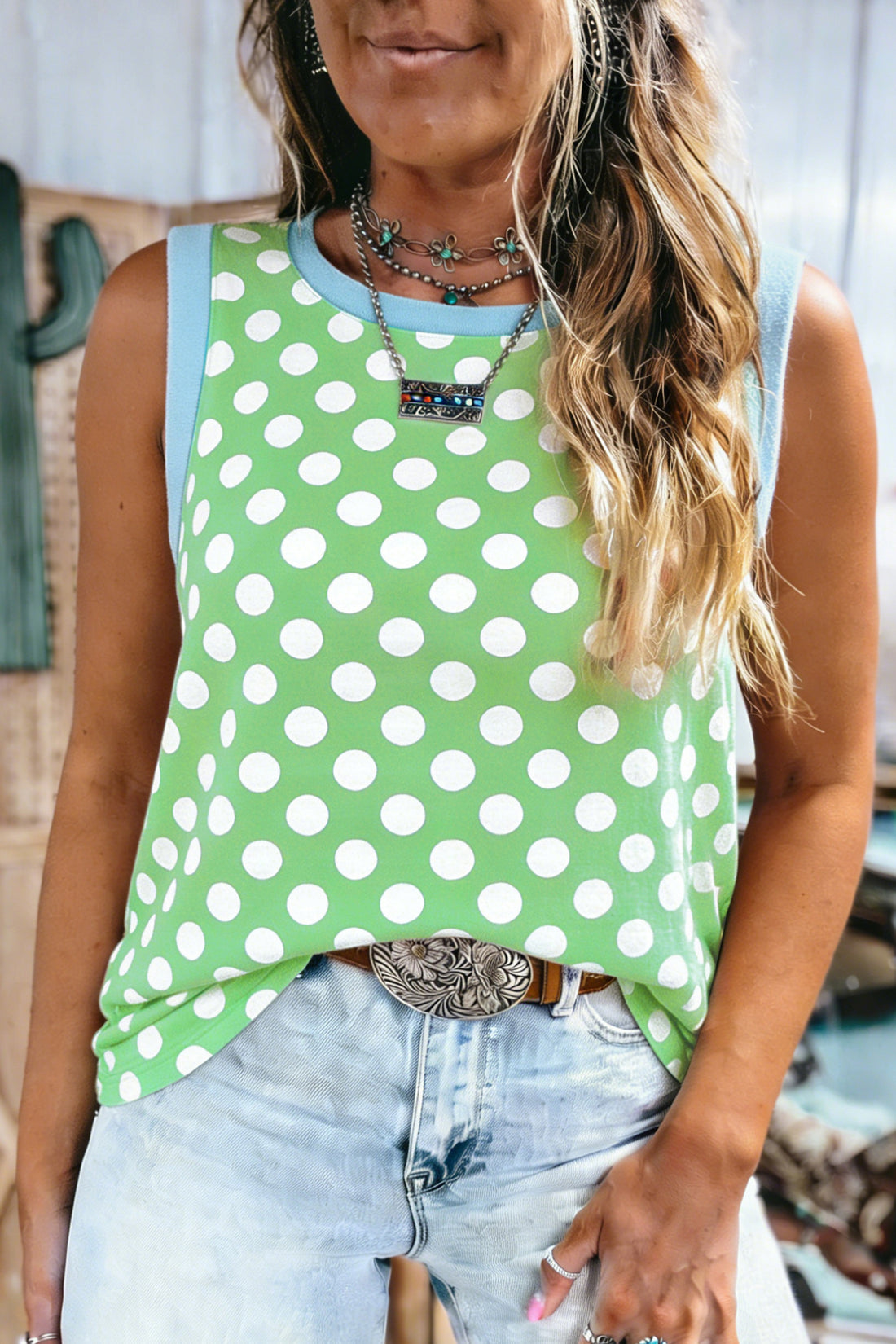Mulher vestindo Green Polka Dot Contrast Trim Round Neck Loose Tank Top verde com bolinhas brancas e detalhes em azul claro, combinada com acessórios boho para suplementos premium naturais para energia e vitalidade.