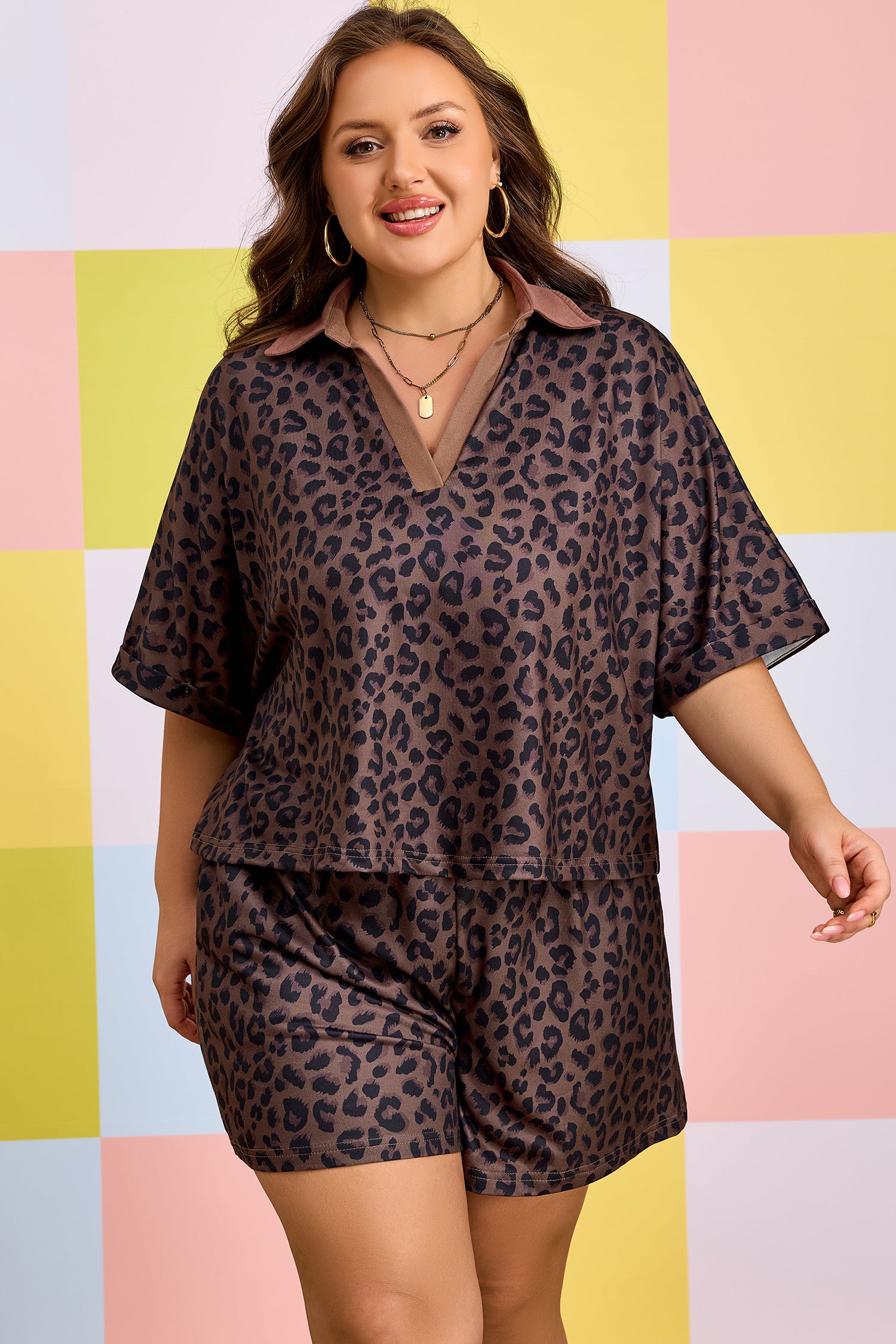 Mulher sorridente vestindo Brown Plus Size Leopard Short Set com estampa de leopardo em fundo colorido, transmitindo conforto e estilo natural.