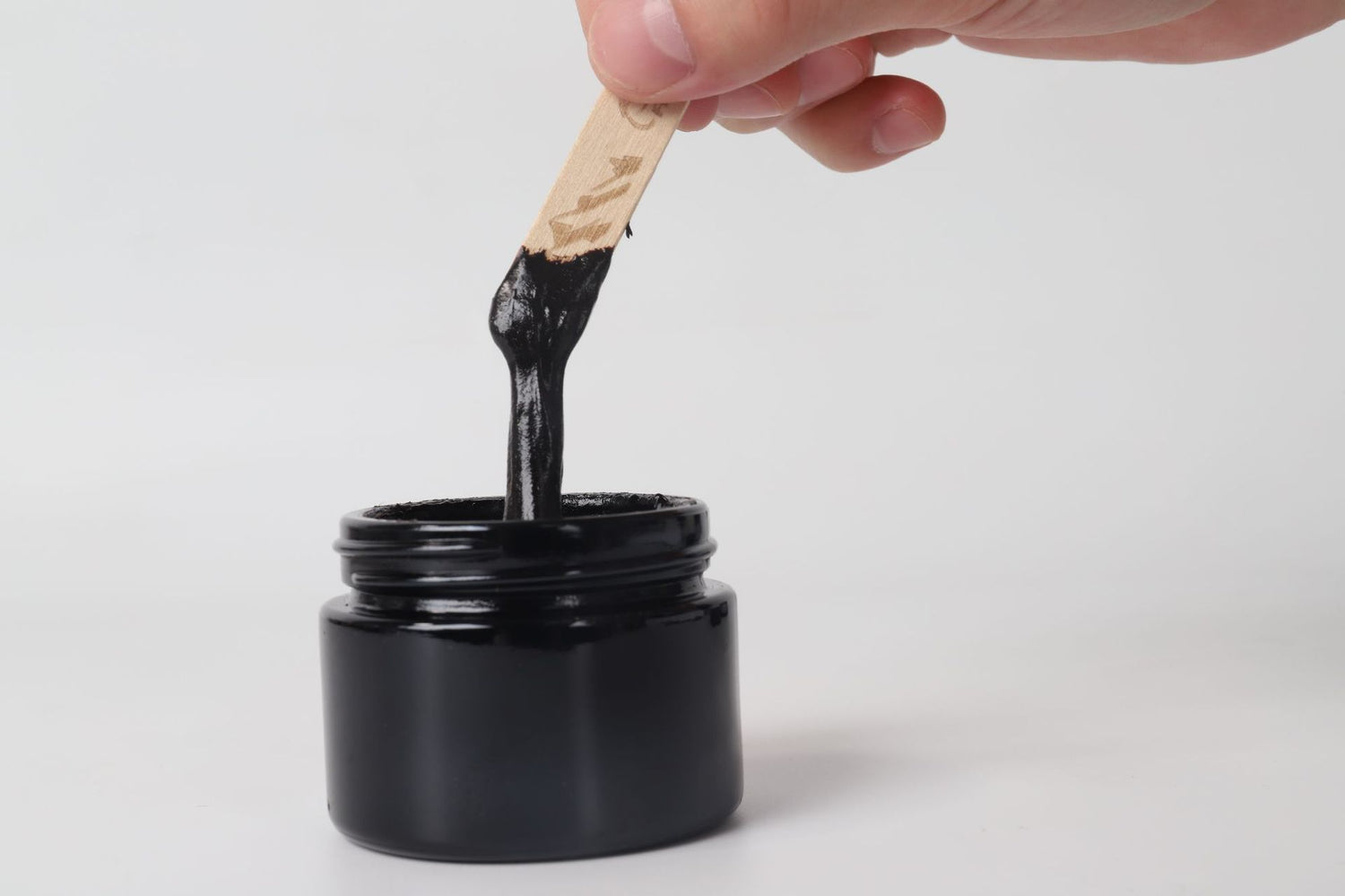 Pure Himalayan Shilajit SoftResin em pote preto, mostrando textura resinosa preta sendo retirada com espátula, suplemento premium natural para energia, vitalidade e saúde cognitiva.