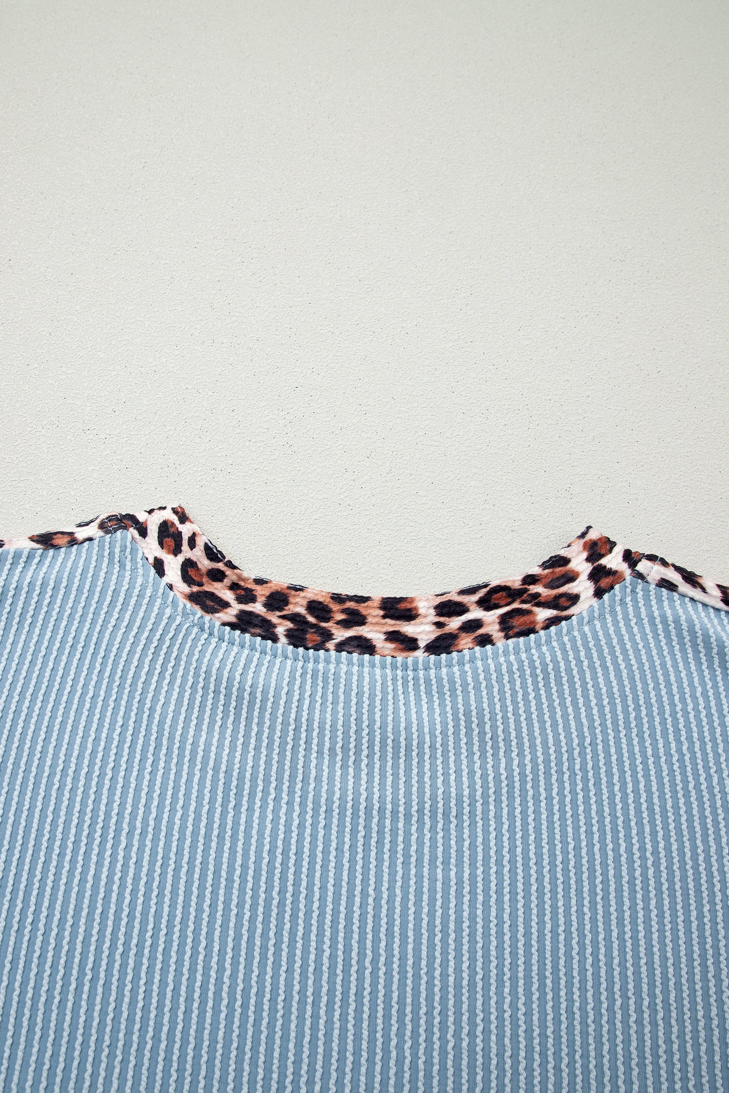 Detalhe do Light Grey Leopard Trim Twist Ribbed Short Set, com tecido cinza claro canelado e acabamento em padrão leopardo, destacando conforto e estilo para suplementos premium naturais para energia, vitalidade e saúde cognitiva, desenvolvidos para o mercado português.