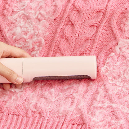 Pessoa utilizando 2-1 Reusable Pet Hair Remover Brush Lint Roller Portable para remover pelos de animal de roupa de malha rosa, promovendo limpeza eficiente e bem-estar natural.