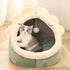 Gato cinza e branco sentado dentro do Adorable Dinosaur Pet House with Toy, uma casa de pelúcia em forma de dinossauro confortável e acolhedora, perfeita para relaxar.