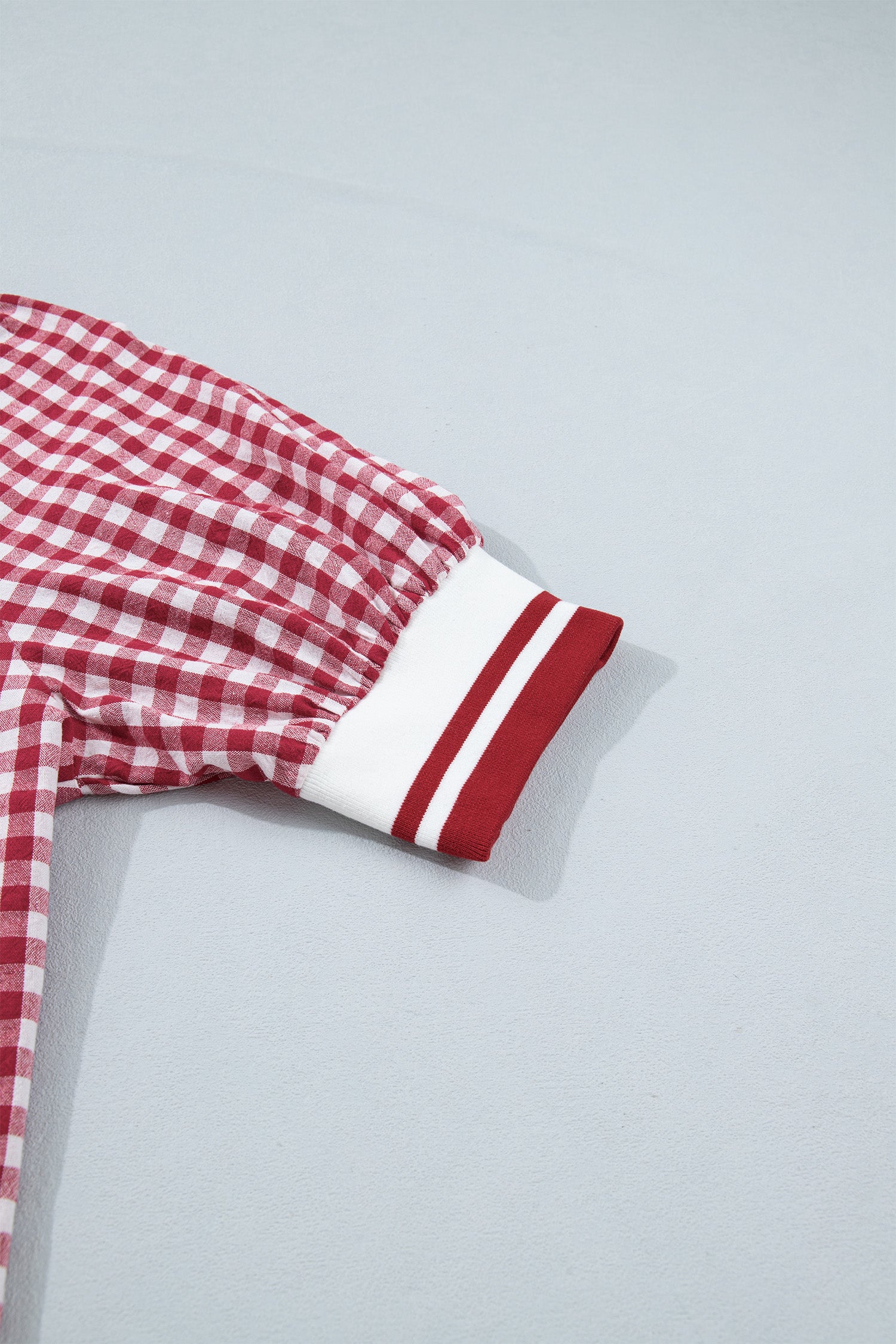 Manga com punho elástico branco com riscas vermelhas da Red Gingham Striped Patchwork Half Zip Blouse, destacando o padrão xadrez vermelho e branco, ideal para um estilo casual e descontraído.