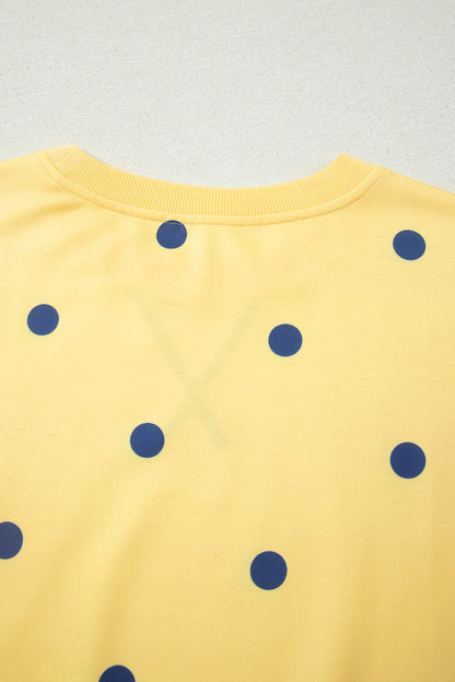 Detalhe das costas da Yellow Polka Dot Print Crossed Seam Detail Oversize Tee, com padrão amarelo e bolinhas azuis, destacando costura cruzada e estilo oversize, ideal para conforto e bem-estar natural.