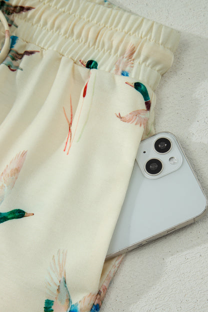 Detalhe do beige mallard duck print oversized tee drawstring short set com bolso, mostrando tecido macio e estampa de pato em ambiente minimalista.
