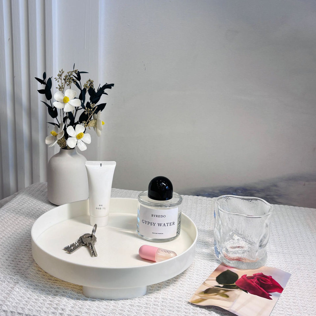 Bandeja branca ins desktop cosmetics storage box tray entrance ornaments storage tray com frases premium naturais para energia, vitalidade e saúde cognitiva, contendo chave, cremes, perfume e decoração floral minimalista sobre mesa clara.