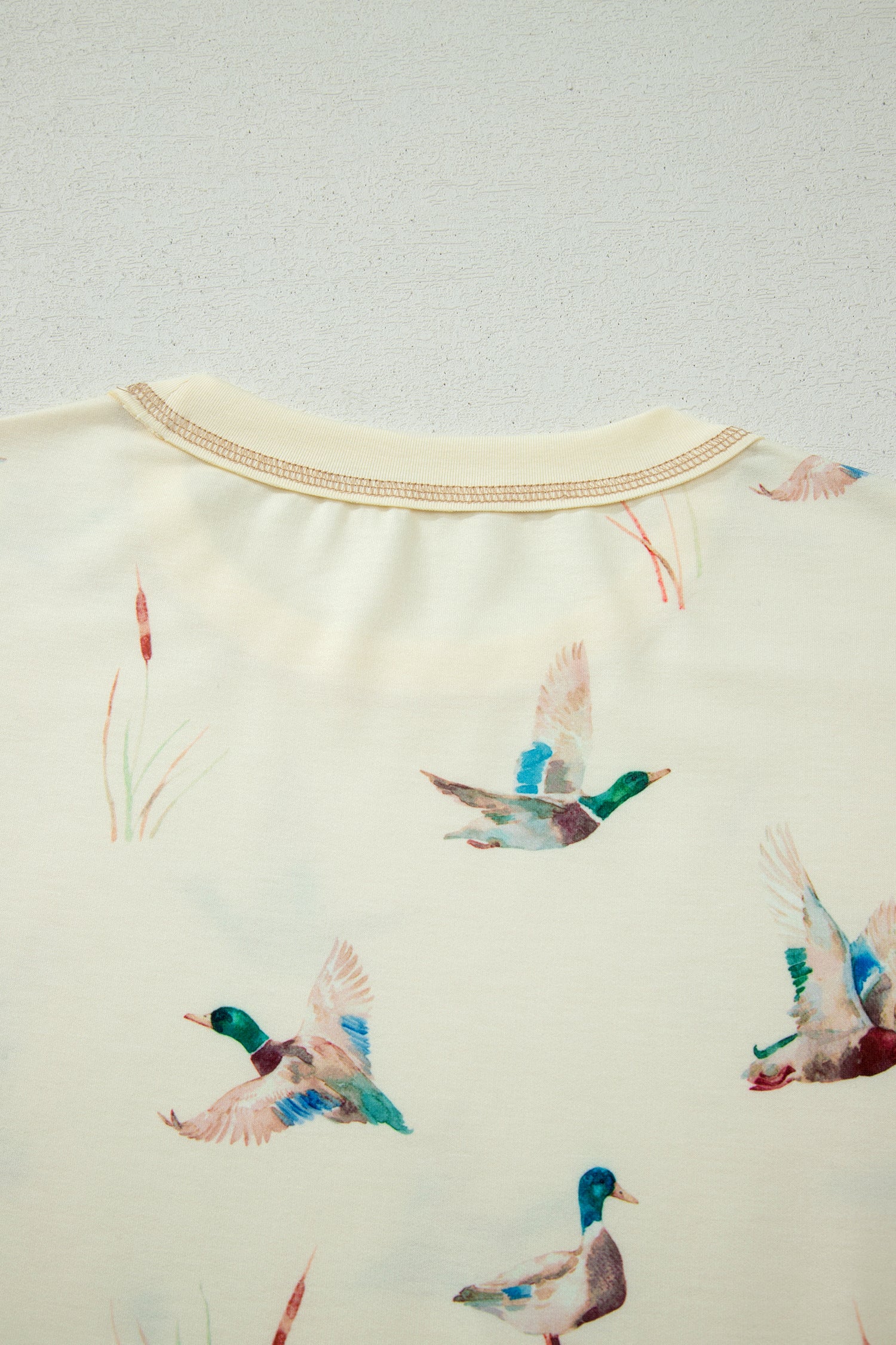 Detalhe do tecido com estampa de patos mallard em voo em Beige Mallard Duck Print Oversized Tee Drawstring Short Set, destacando design suave e natural, associado a suplementos premium naturais para energia, vitalidade e saúde cognitiva.
