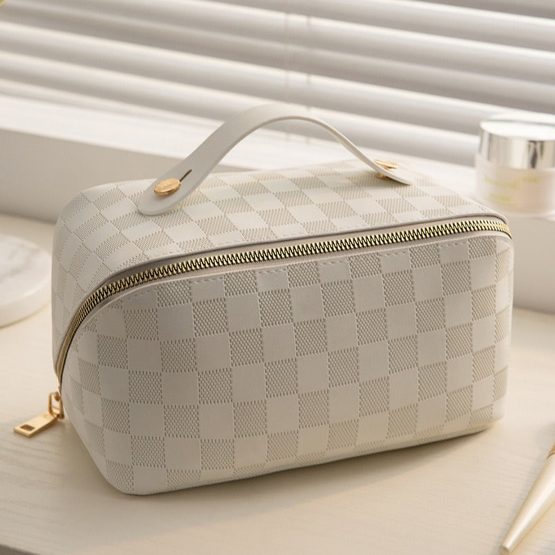 Bolsa de maquiagem portátil com padrão xadrez em tom creme, ideal para viagens, destacando capacidade grande e design compacto da Checkered Pillow Bag Makeup Bag Women&