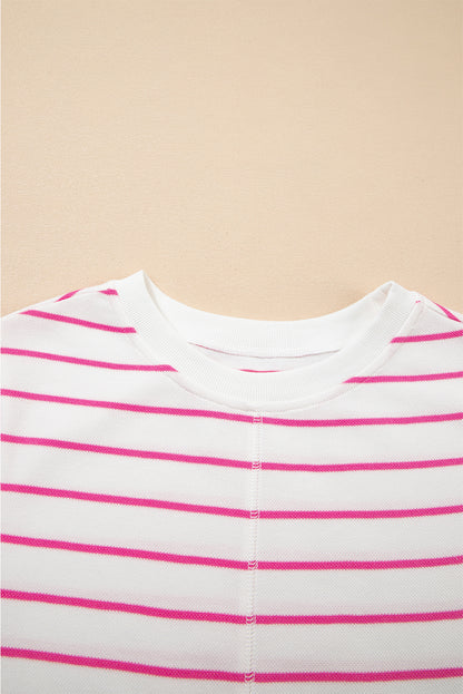 Parte superior do "Sail Blue Casual Striped Tee and Wide Leg Pants Set" com padrão de riscas cor-de-rosa em fundo branco sobre superfície bege, destacando estilo casual.