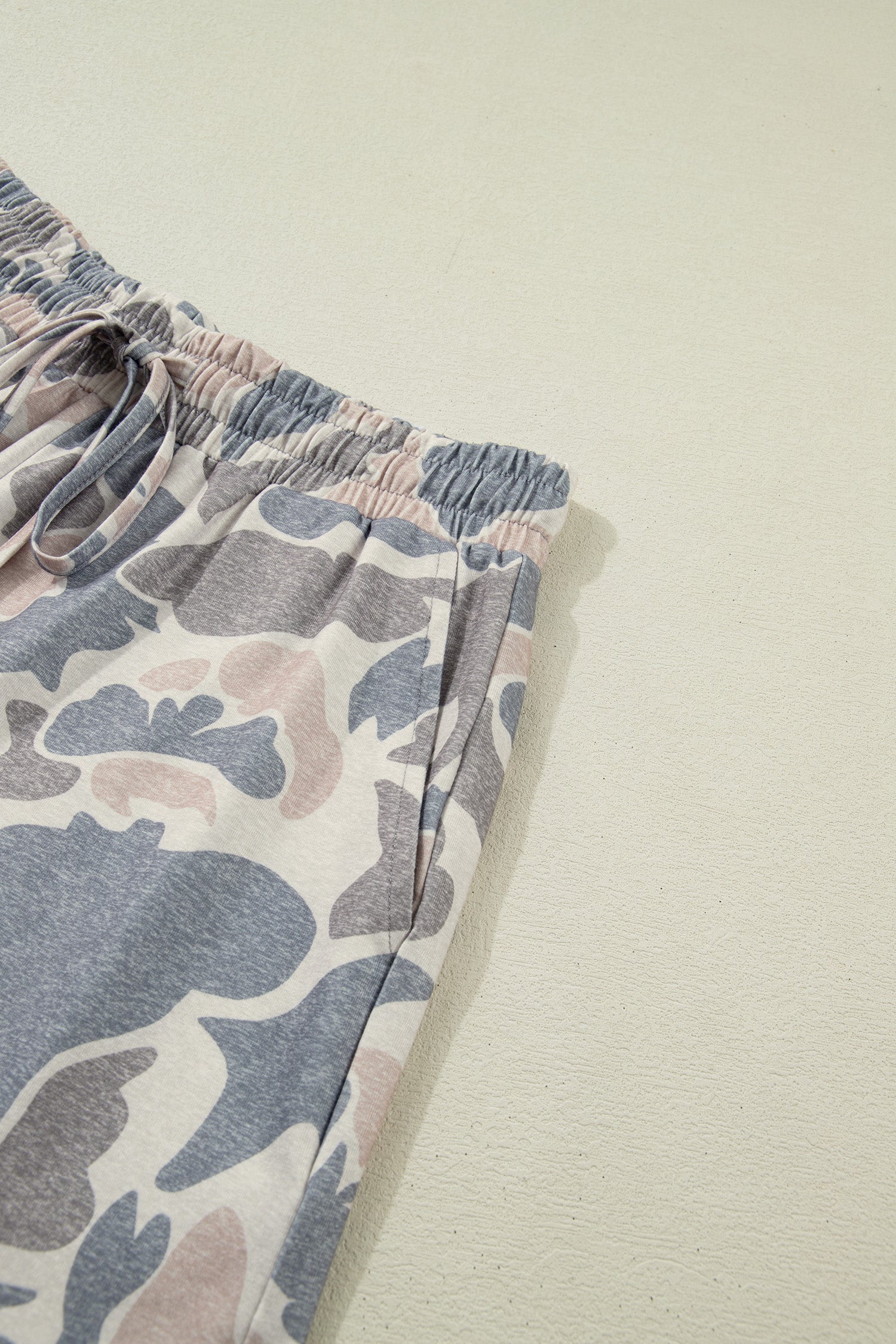 Parte inferior do Multicolour Camouflage Loose Tee Drawstring Shorts 2pcs Outfit com padrão camuflado em tons suaves de cinza e bege, suplementando energia e vitalidade.