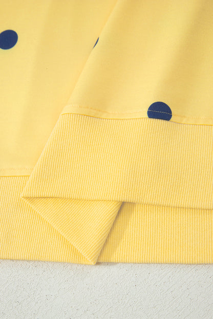 Detalhe do tecido amarelo com estampa de bolinhas azuis do Yellow Polka Dot Print Crossed Seam Detail Oversize Tee, destacando acabamento em malha canelada.