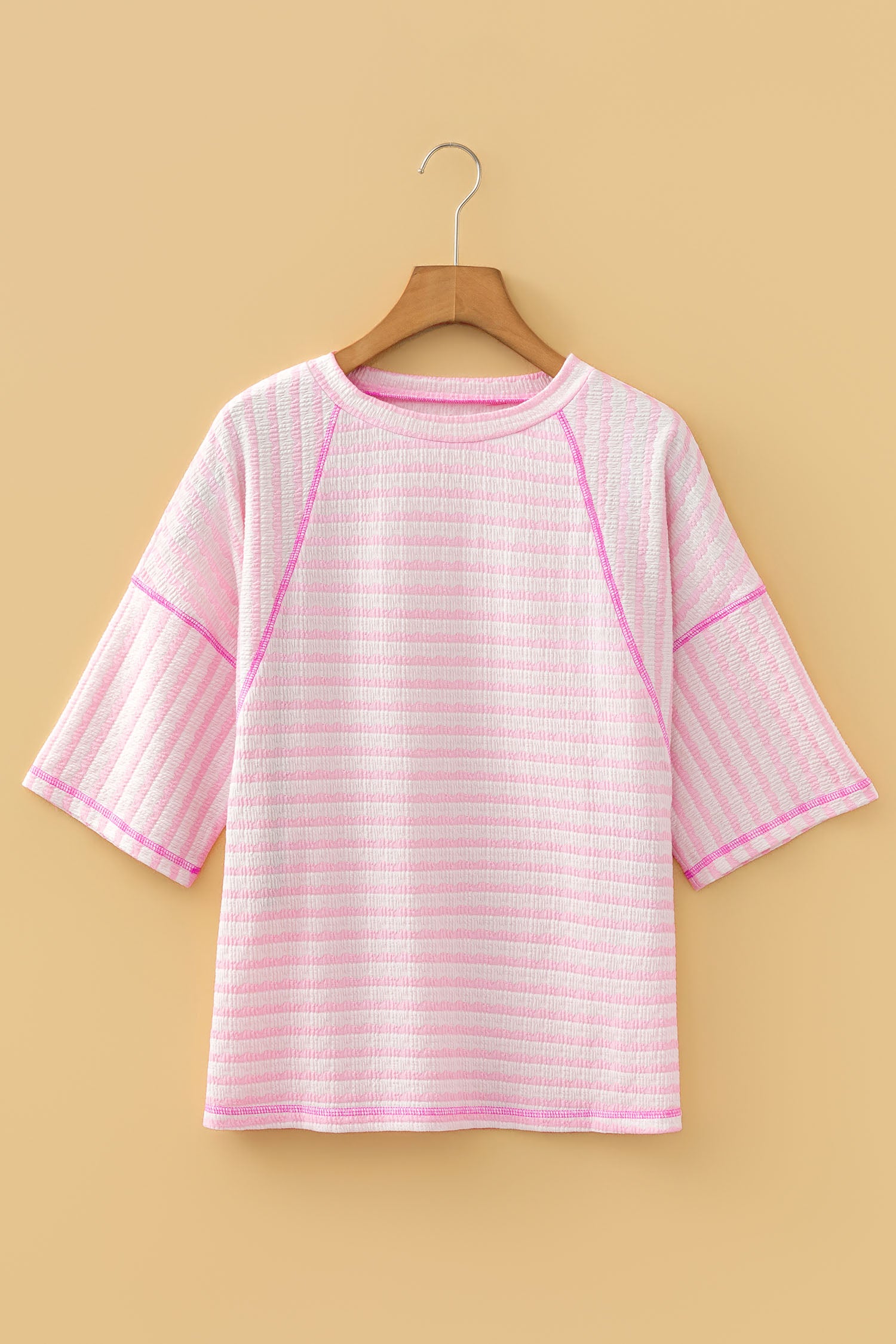 Apricot Stripe Textured Knit Split Hem Half Sleeve Loose Top em malha texturizada com riscas em tons de rosa e branco, com mangas meia e corte solto, ideal para um estilo casual confortável.