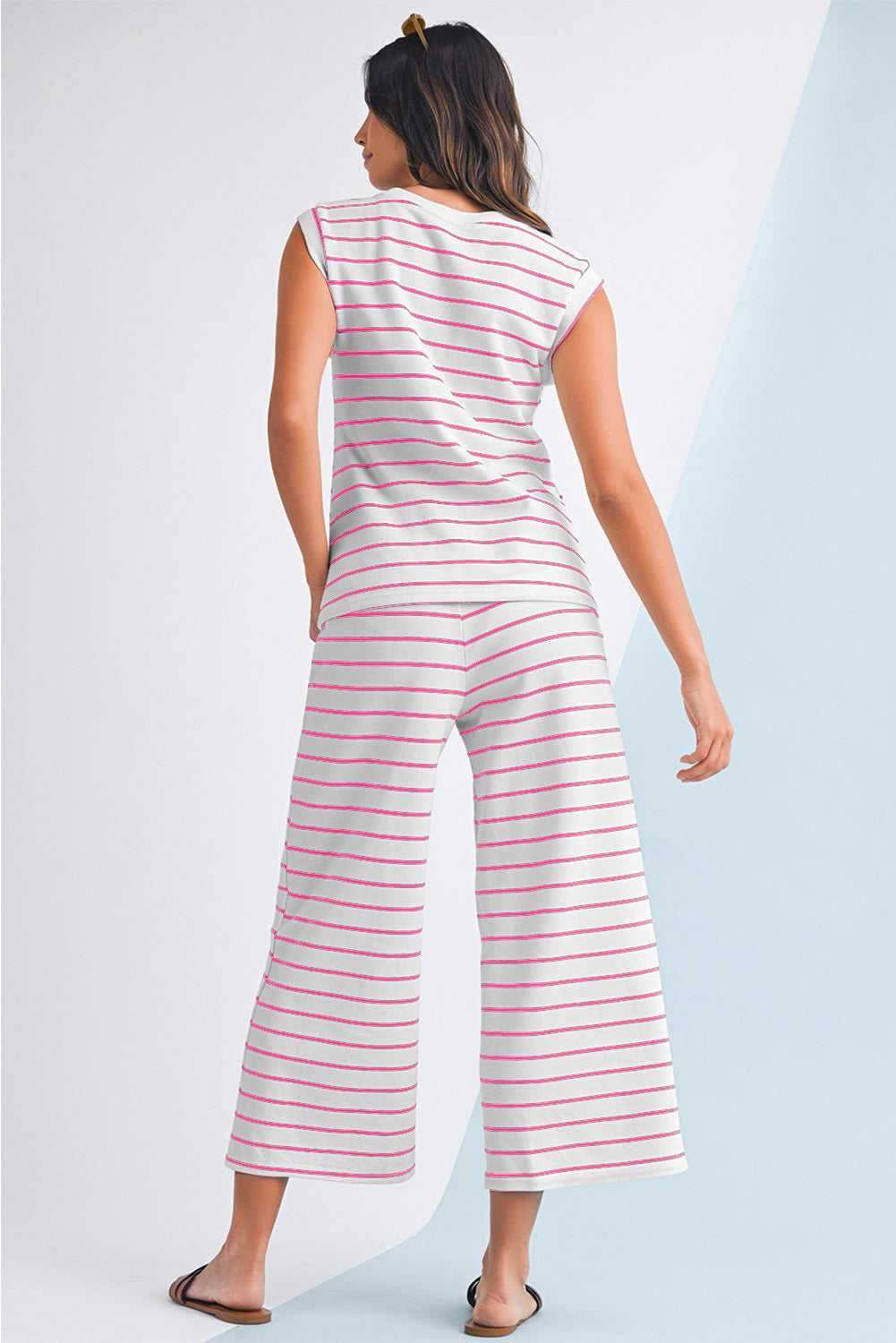 Mulher vista de costas usando o conjunto Sail Blue Casual Striped Tee and Wide Leg Pants Set, com listras horizontais em tons suaves, demonstrando conforto e estilo casual.