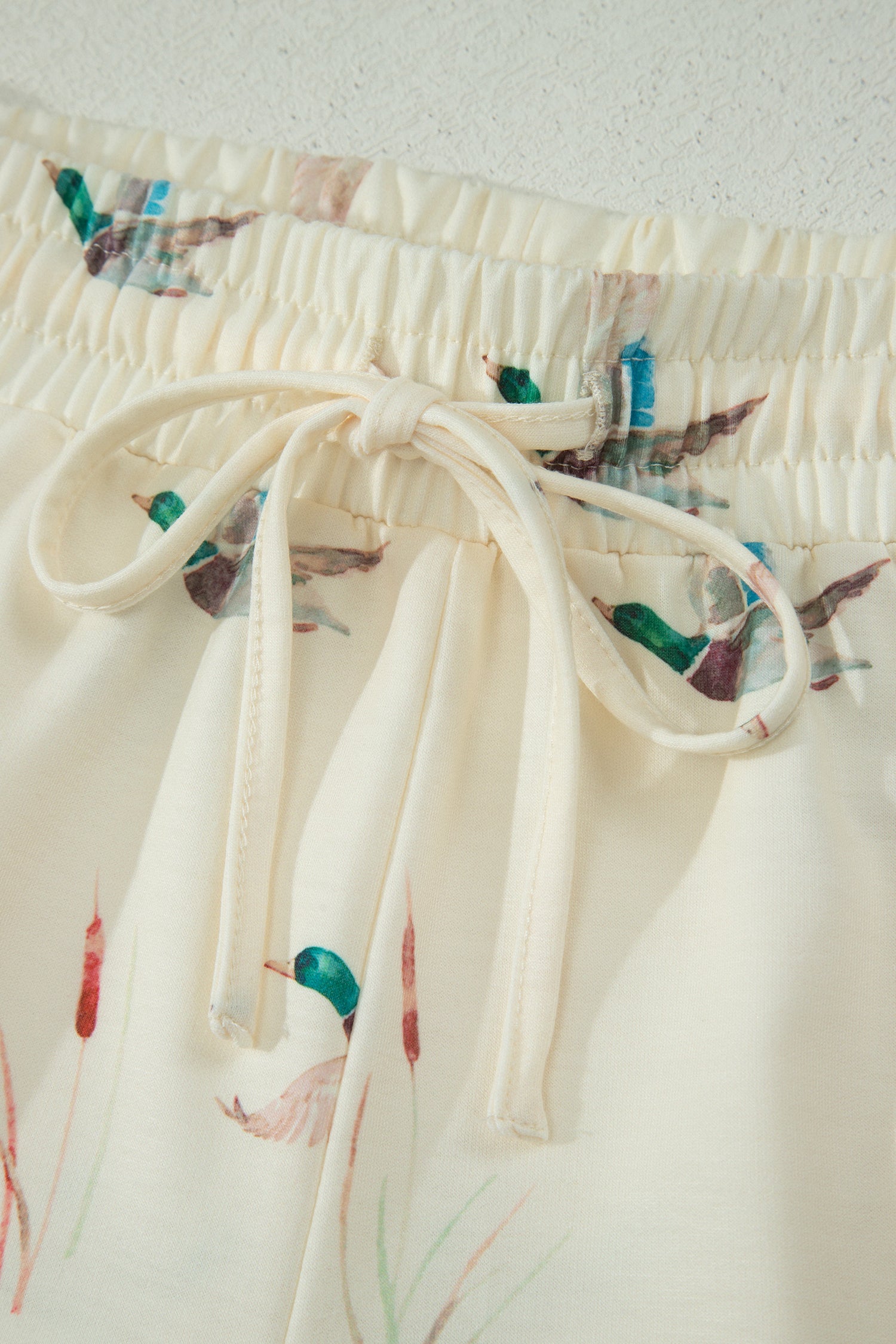 Detalhe do laço e estampa de patos em bege no Beige Mallard Duck Print Oversized Tee Drawstring Short Set, ideal para um look confortável e casual. suplementos premium naturais para energia, vitalidade e saúde cognitiva, desenvolvidos para o mercado português.