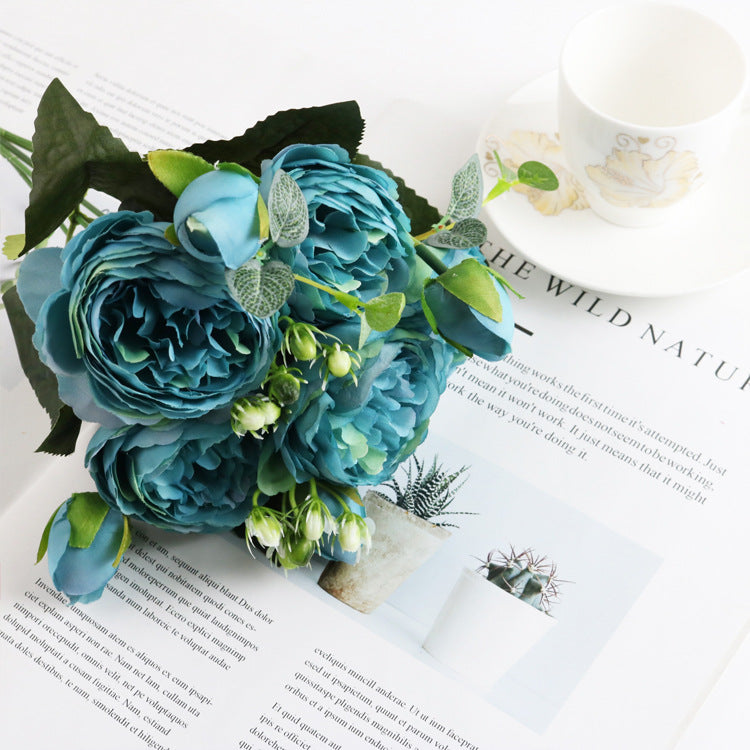 Arranjo de 5 Small Peonies Korean Small Bouquets 5 Philips Rose Simulation Flowers Household Wedding Rose Bouquets em tom azul, com folhas verdes, sobre revista e xícara branca, associado a suplementos premium naturais para energia, vitalidade e saúde cognitiva.