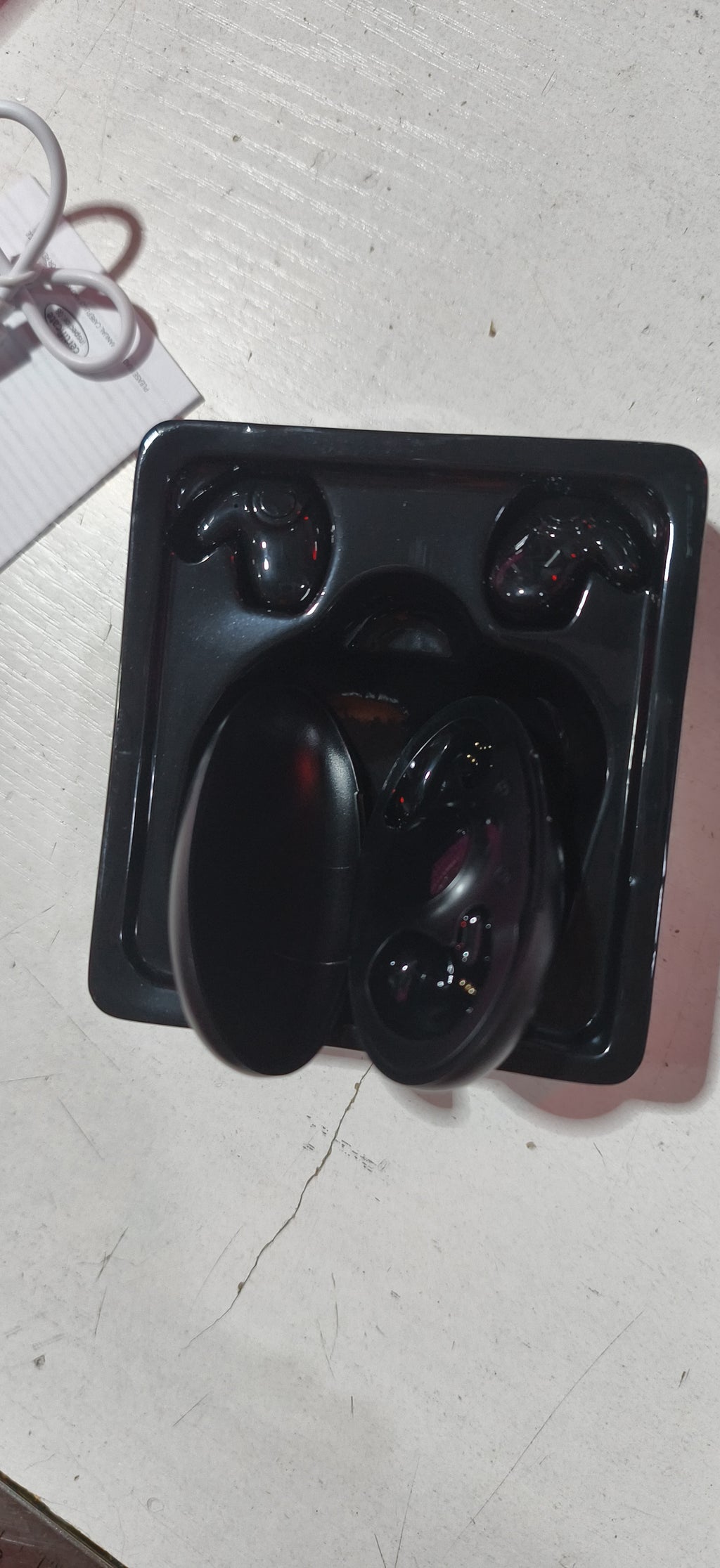 Fone Bluetooth sem fio na palma da mão, mostrando o tamanho compacto