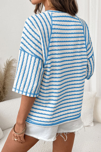 Mulher vestindo Apricot Stripe Textured Knit Split Hem Half Sleeve Loose Top azul e branco, peça solta com malha texturizada, destacando conforto e estilo casual para suplementos premium naturais para energia, vitalidade e saúde cognitiva, desenvolvidos para o mercado português.