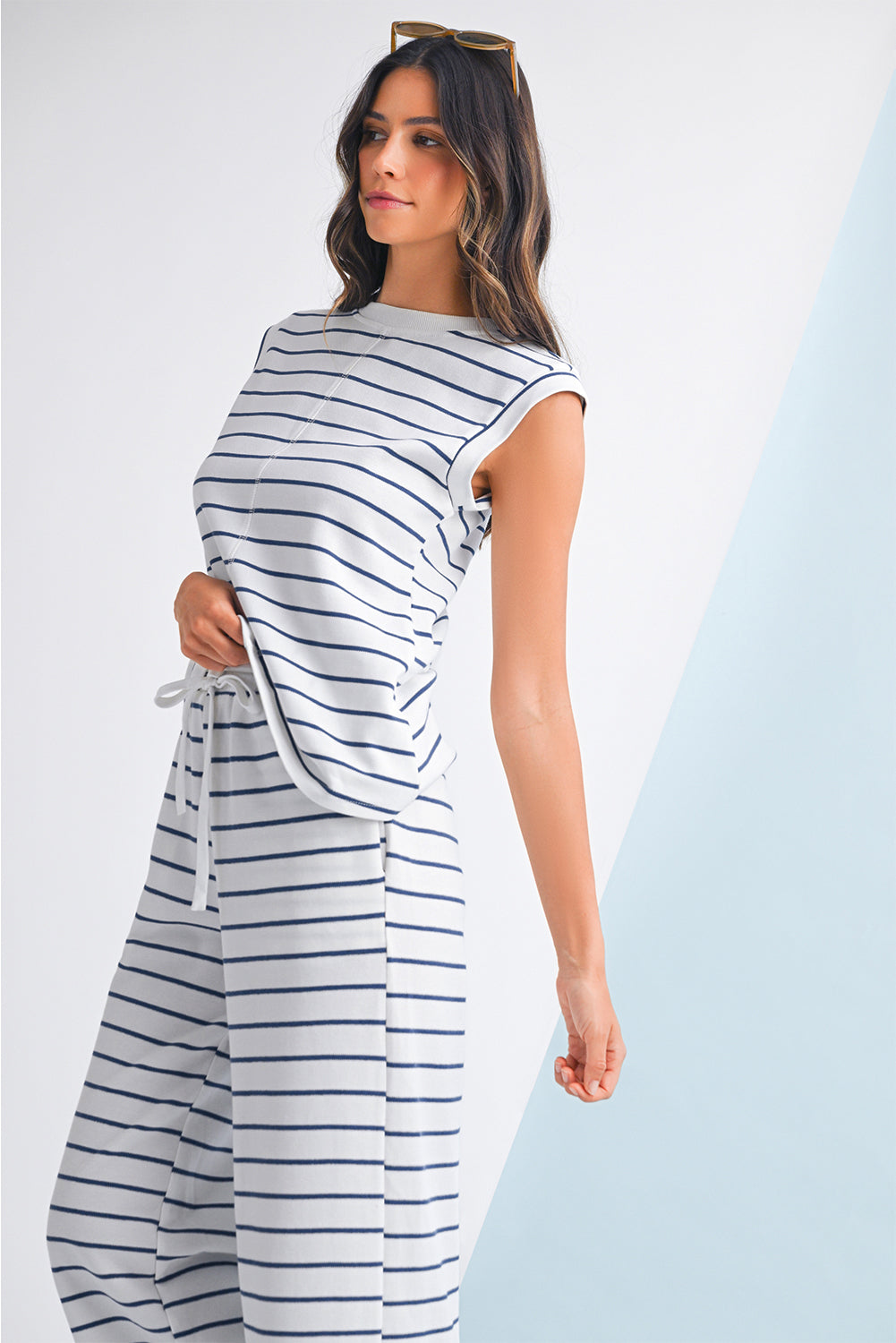 Mulher elegante vestindo o conjunto Sail Blue Casual Striped Tee and Wide Leg Pants Set, com listras azuis e brancas, ideal para um estilo casual e confortável, destacando suplementos premium naturais para energia, vitalidade e saúde cognitiva desenvolvidos para o mercado português.