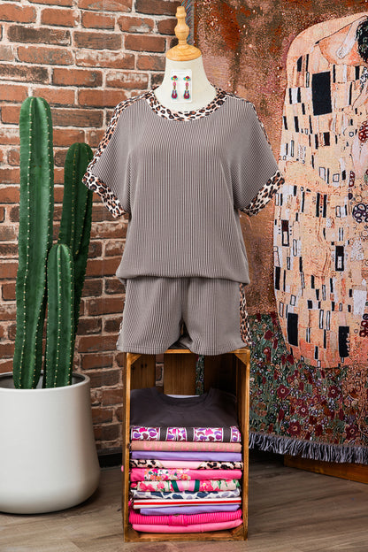 Conjunto Light Grey Leopard Trim Twist Ribbed Short Set exposto em manequim, em ambiente acolhedor com plantas e acessórios, promovendo suplementos premium naturais para energia, vitalidade e saúde cognitiva.