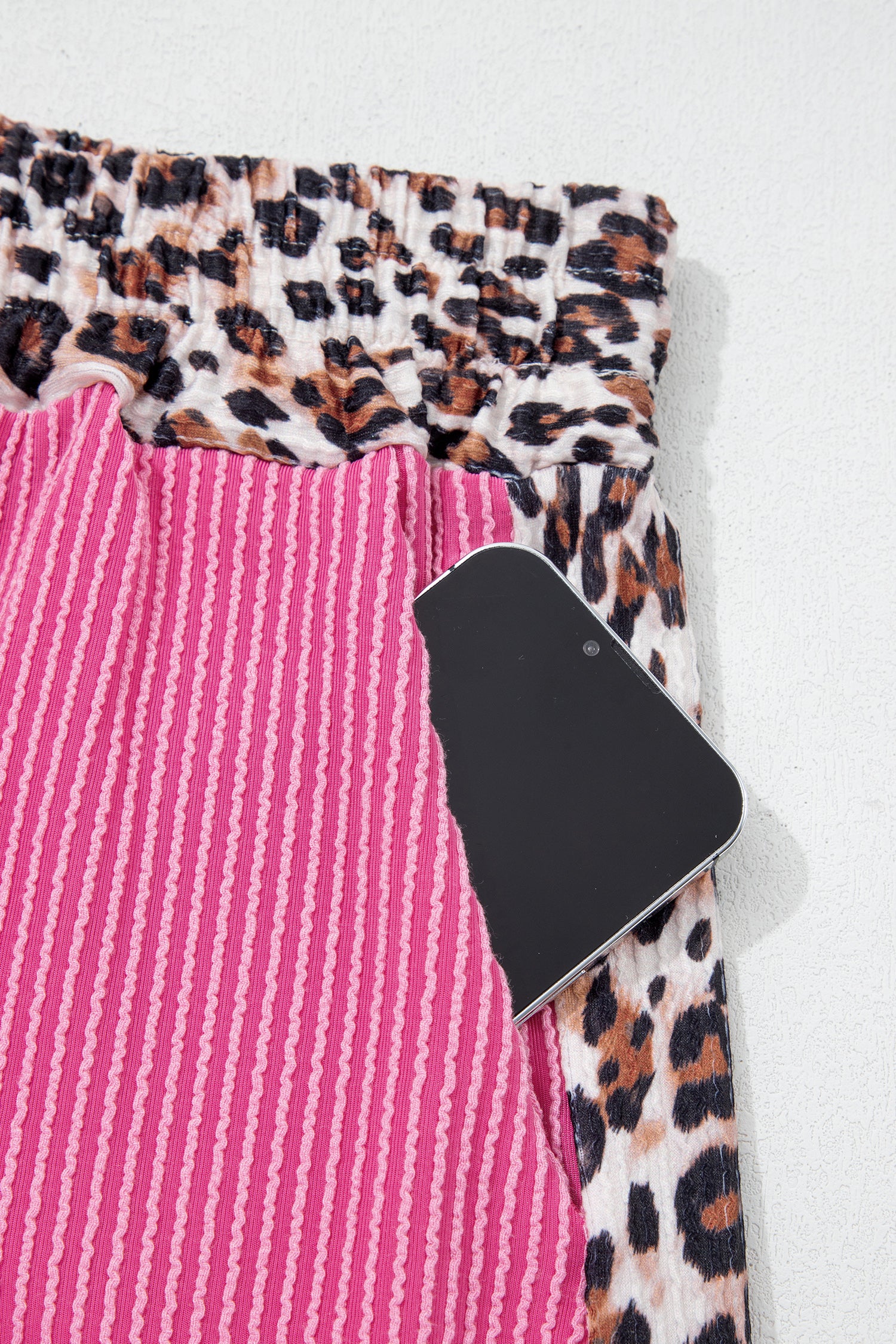 Detalhe do Light Grey Leopard Trim Twist Ribbed Short Set mostrando tecido canelado rosa com acabamento em padrão leopardo, associado a suplementos premium naturais para energia, vitalidade e saúde cognitiva.
