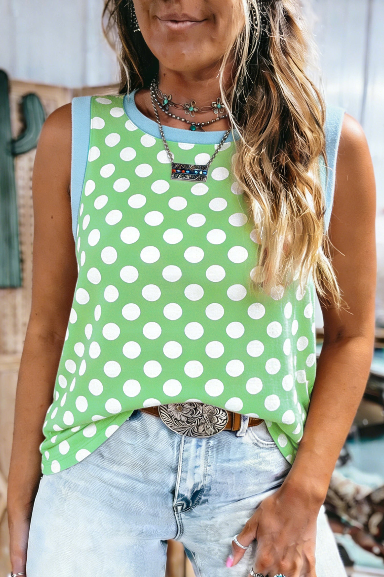 Mulher vestindo Green Polka Dot Contrast Trim Round Neck Loose Tank Top verde com bolinhas brancas e detalhes em azul claro, combinada com acessórios boho para suplementos premium naturais para energia e vitalidade.