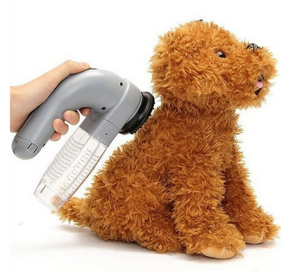 Pessoa usando Electric Pet Hair Portable Pet Massage Cleaning Brush para remover pelos de pelúcia marrom simulando um cachorro, promovendo limpeza eficaz e conforto.
