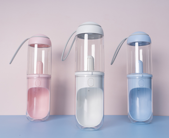 Três unidades do Outdoor Travel Pet Water Dispenser Pet Dog Cat Water Bottle em cores pastel rosa, branco e azul, ideais para hidratação natural e suplementação para energia e vitalidade.
