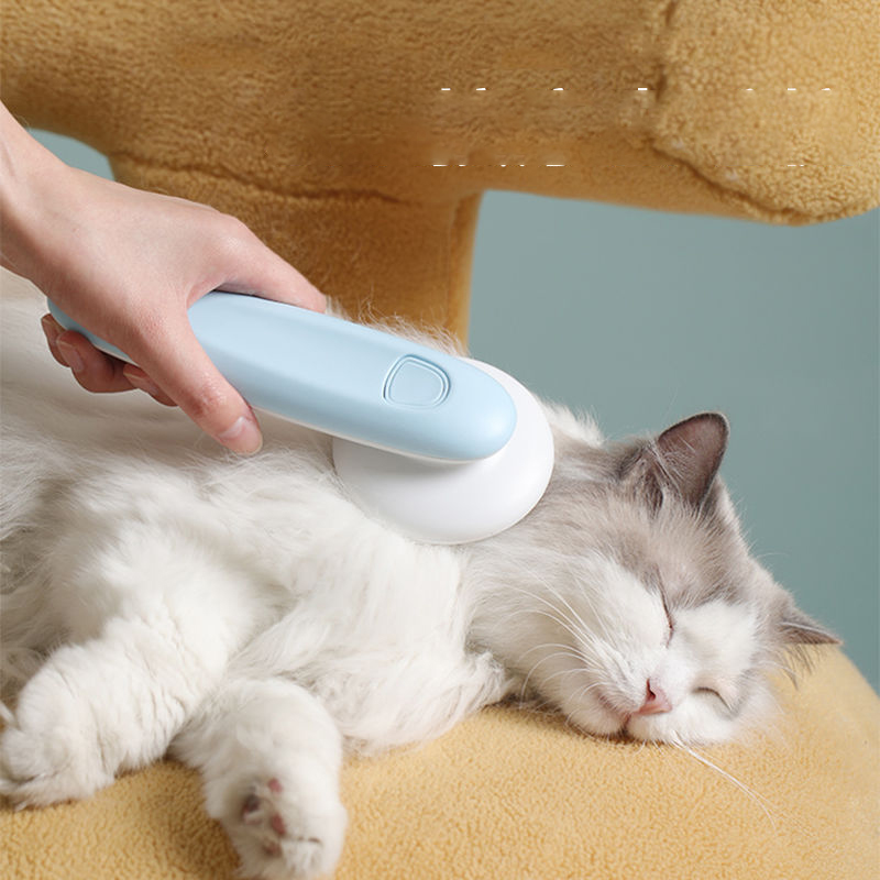 Pessoa a usar UFO Pet Massage Comb Cats Dog Grooming Combs Brush para escovar e massagear suavemente um gato branco e cinza relaxado, promovendo bem-estar natural e cuidado eficaz.
