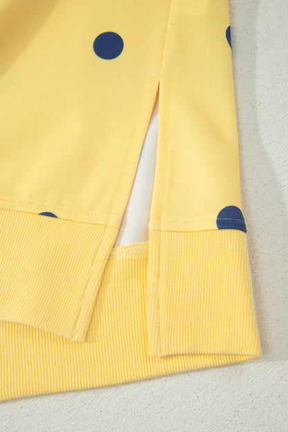 Detalhe da Yellow Polka Dot Print Crossed Seam Detail Oversize Tee em tecido amarelo com pontos azuis, com costura cruzada e acabamento canelado na barra, destacando qualidade e estilo.