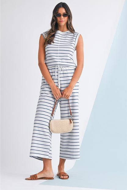 Mulher usando o conjunto Sail Blue Casual Striped Tee and Wide Leg Pants Set, com regata listrada azul e branca, calças largas e acessórios casuais, transmitindo conforto e estilo.