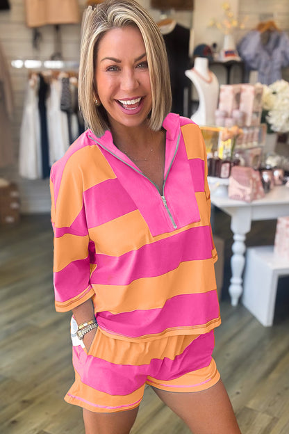 Mulher sorridente vestindo Pink Seam Detail Half Zip Tee Casual Shorts 2pcs Set listrado em rosa e laranja, em ambiente de loja casual, promovendo suplementos premium naturais para energia, vitalidade e saúde cognitiva.